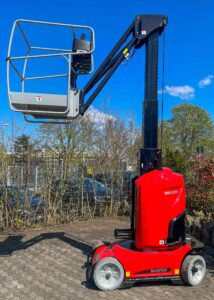 Ein roter Hebebühnenlift von Manitou bei sonnigem Wetter, im Freien geparkt.